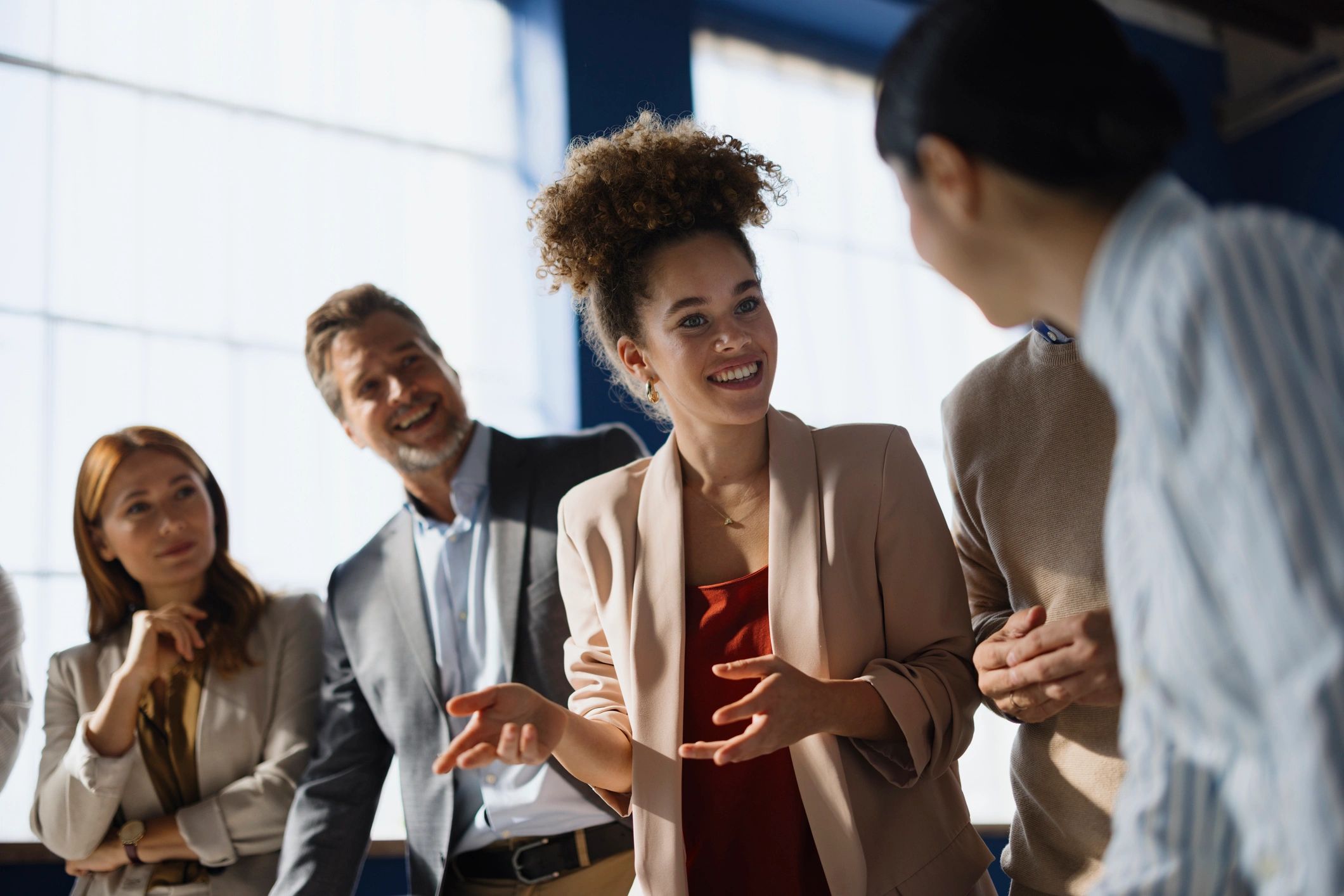 Businesswoman speaking with colleagues in a collaborative office setting